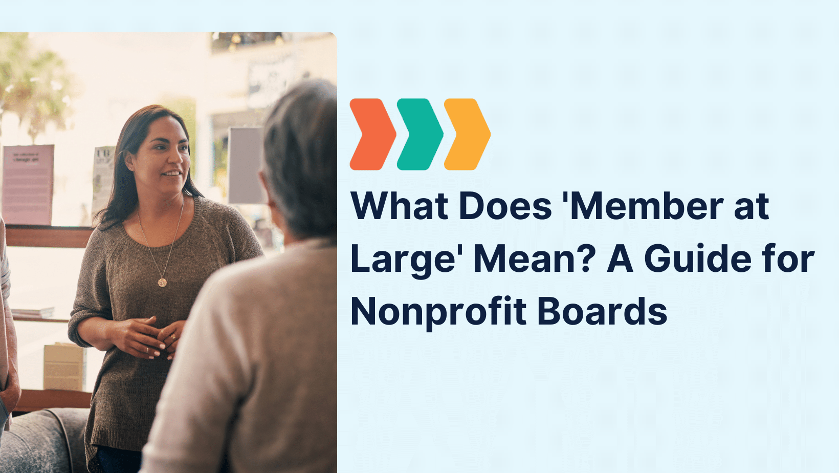 A diverse group of people engaged in a discussion in a bright community space, illustrating collaboration on a nonprofit board. Text overlay reads: “What Does 'Member at Large' Mean? A Guide for Nonprofit Boards.”
